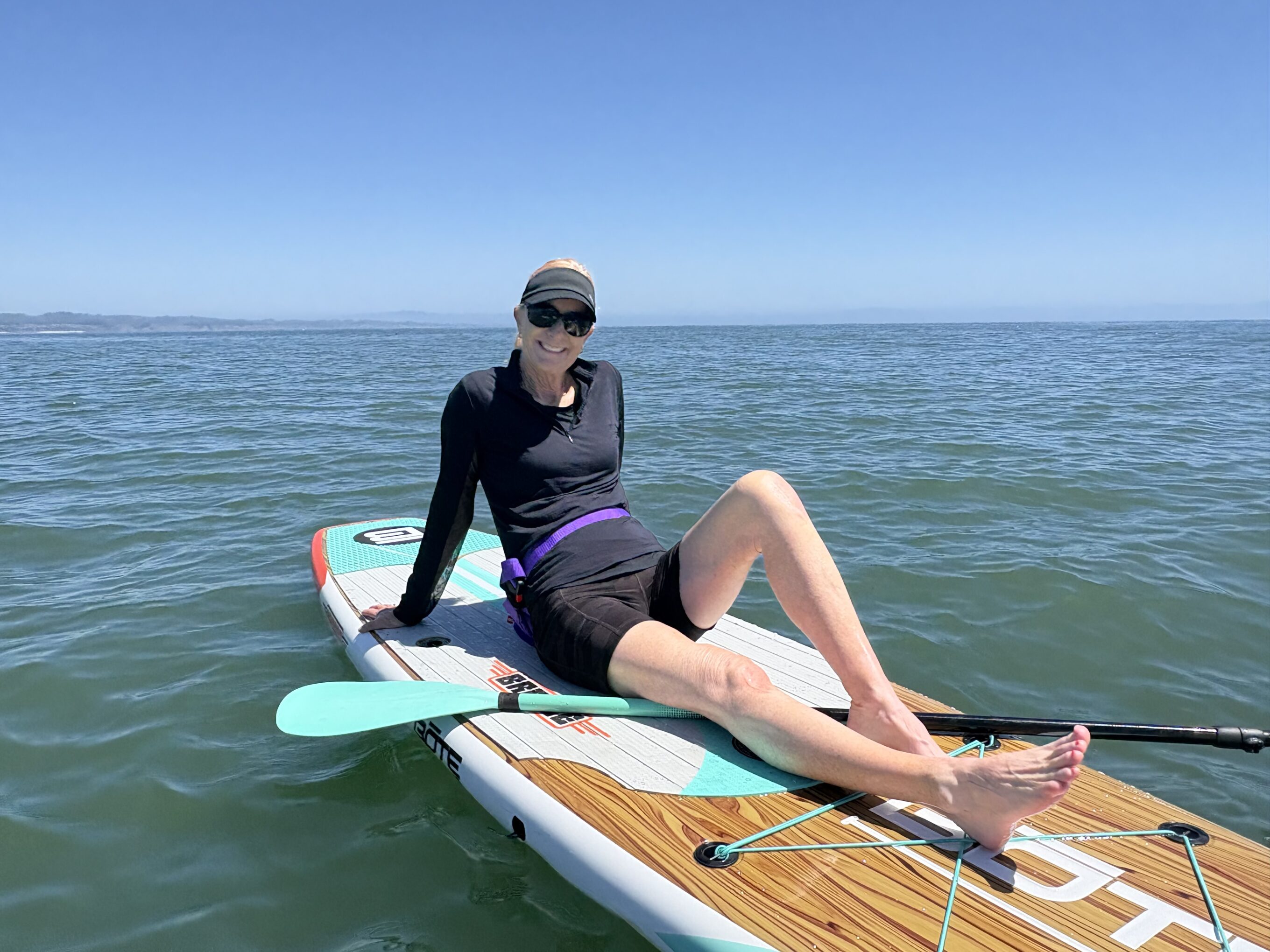 a woman sitting on a paddle board