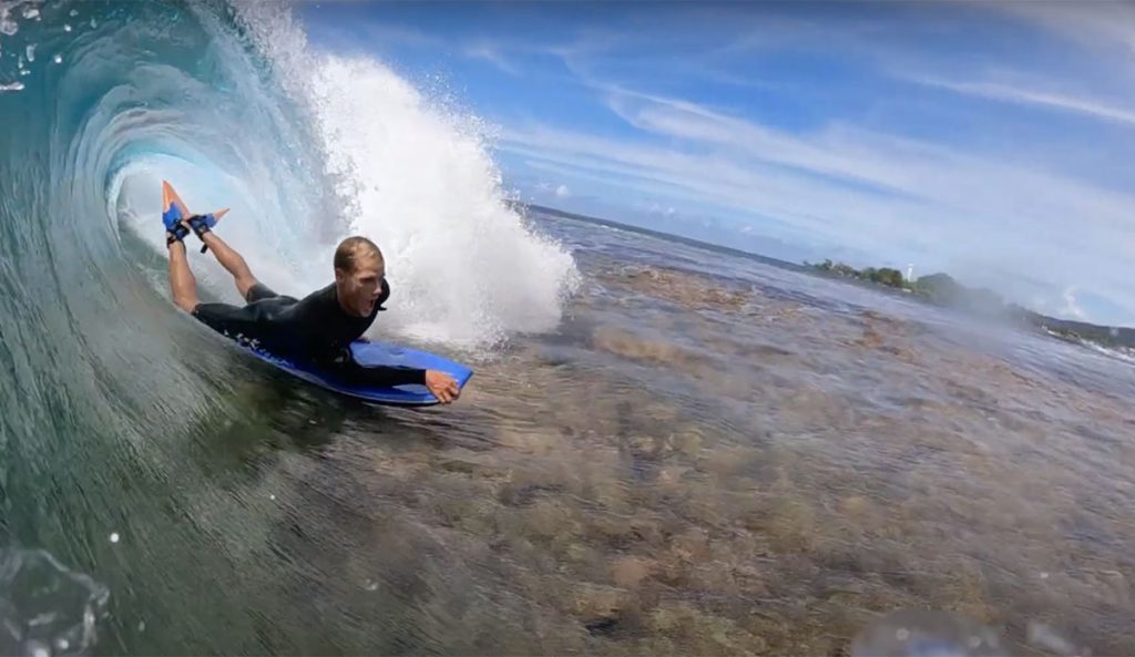 bodyboarders in Tahiti over dry reef