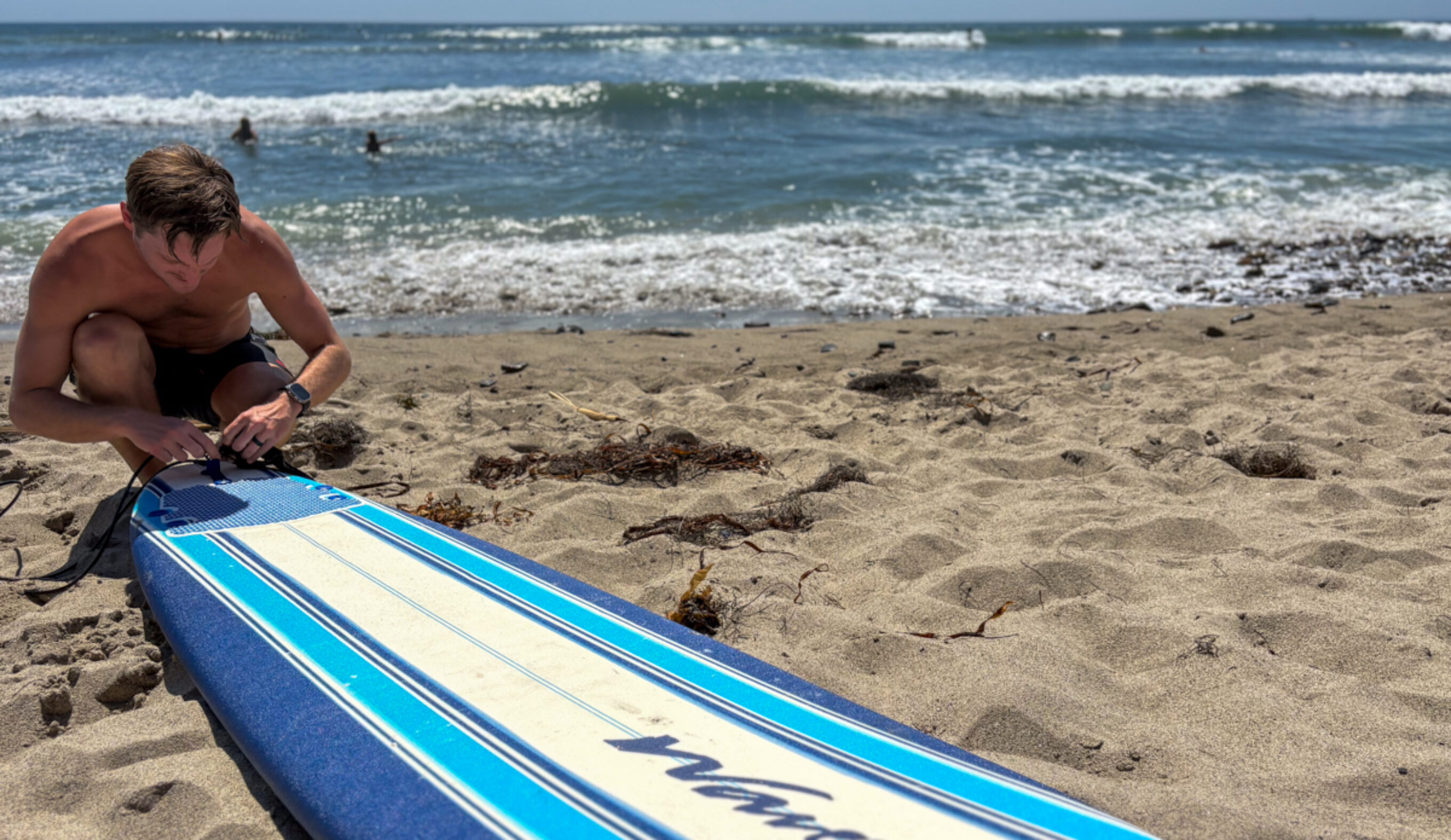Dylan attaches a leash to a wavestorm surfboard