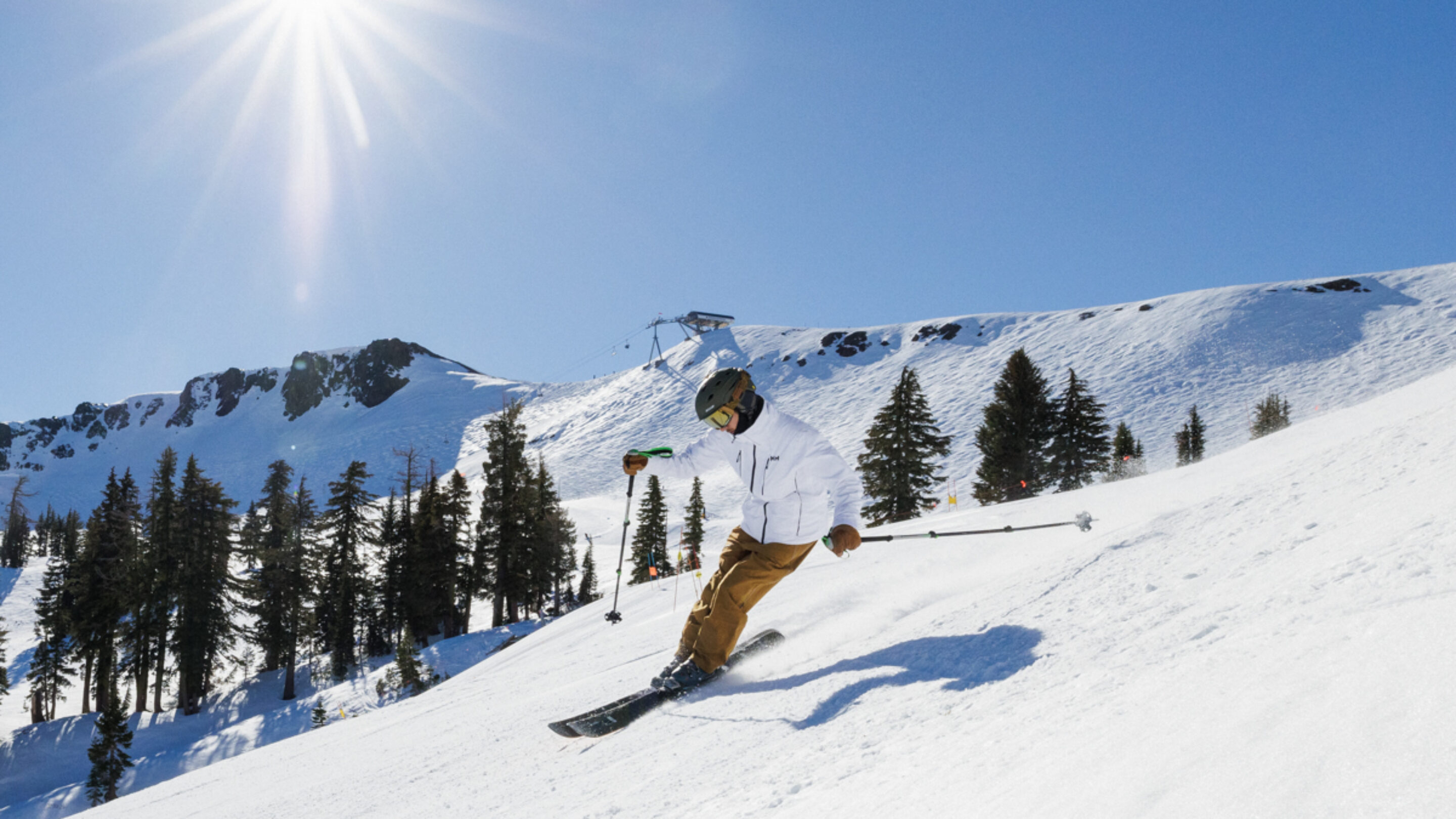 skiing in the HH Alpha 4.0 ski jacket and flylow baker bibs