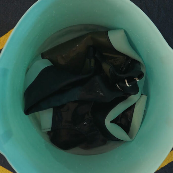 wetsuit being cleaned in a bucket