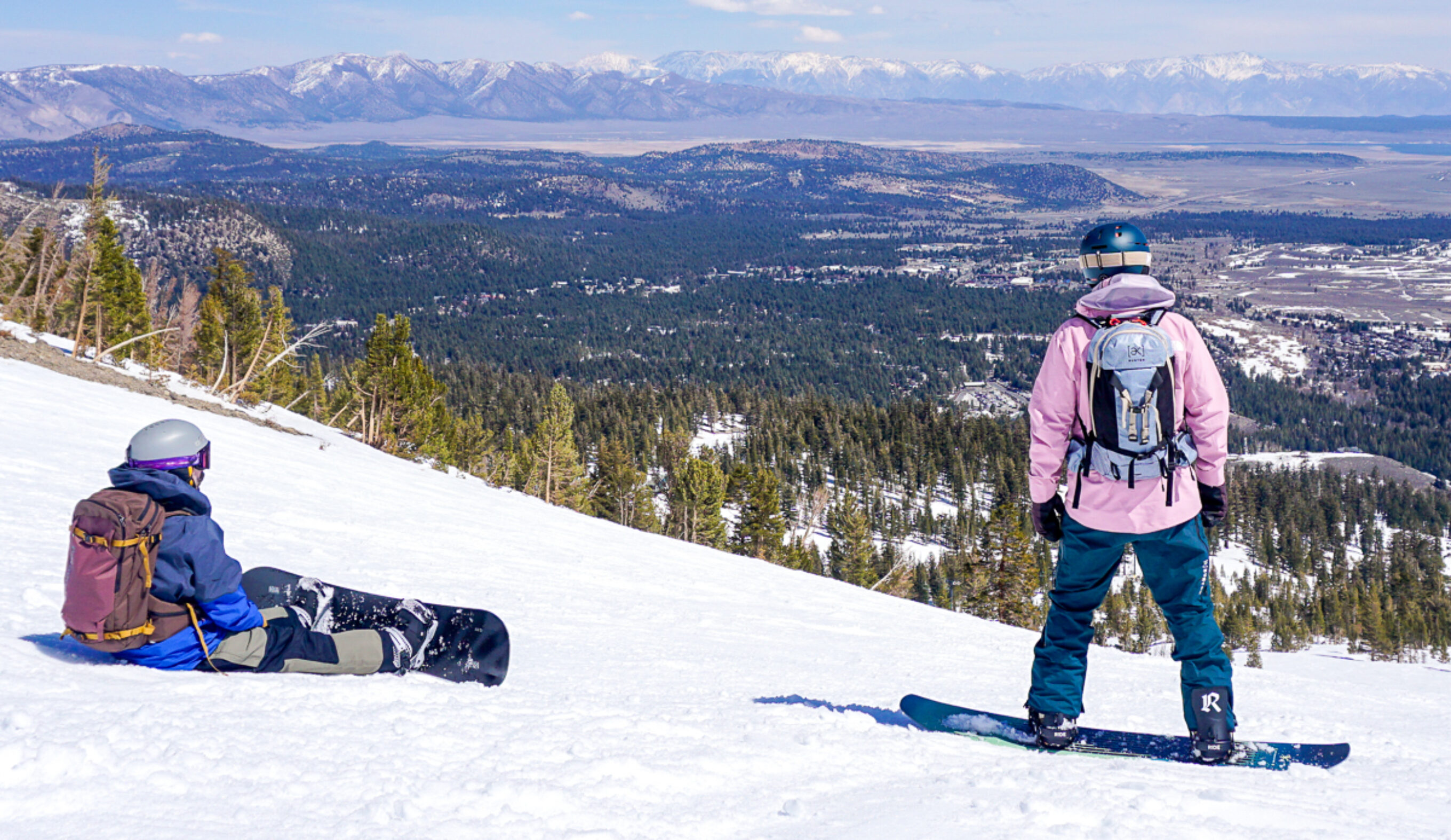 two men snowboarding looking at view