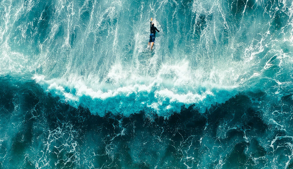 man paddling over waves like microscopic particles do