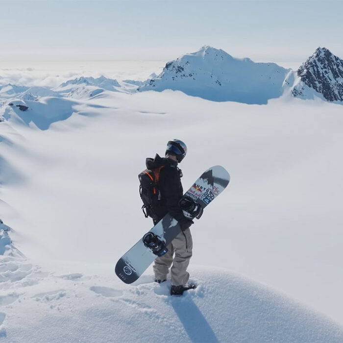 Ben Ferguson standing in Alaska with a snowboard