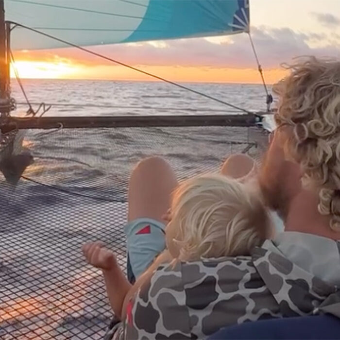 John John Florence sitting on a boat with his son.