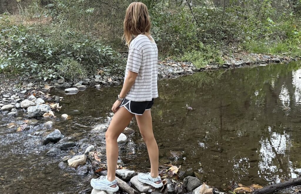 a woman crossing a stream