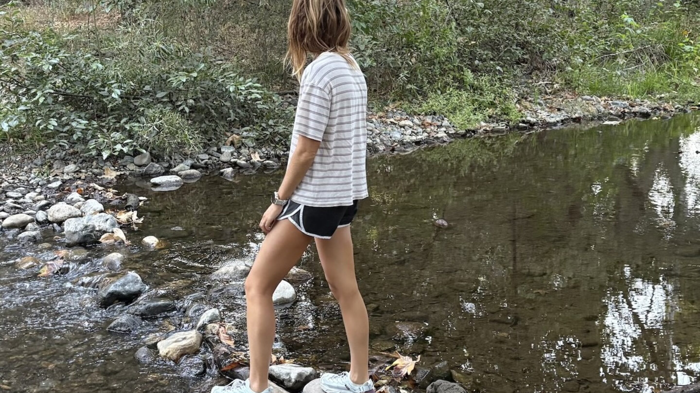 a woman crossing a stream