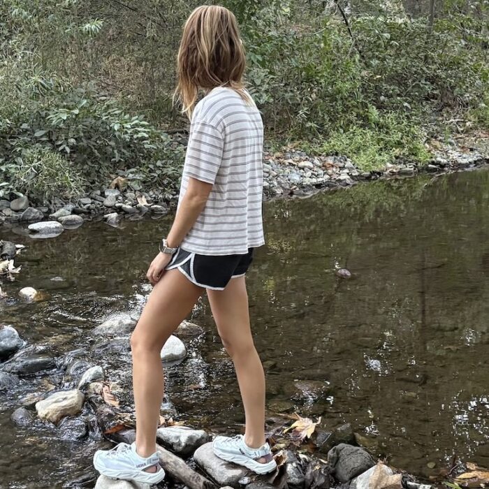 a woman crossing a stream