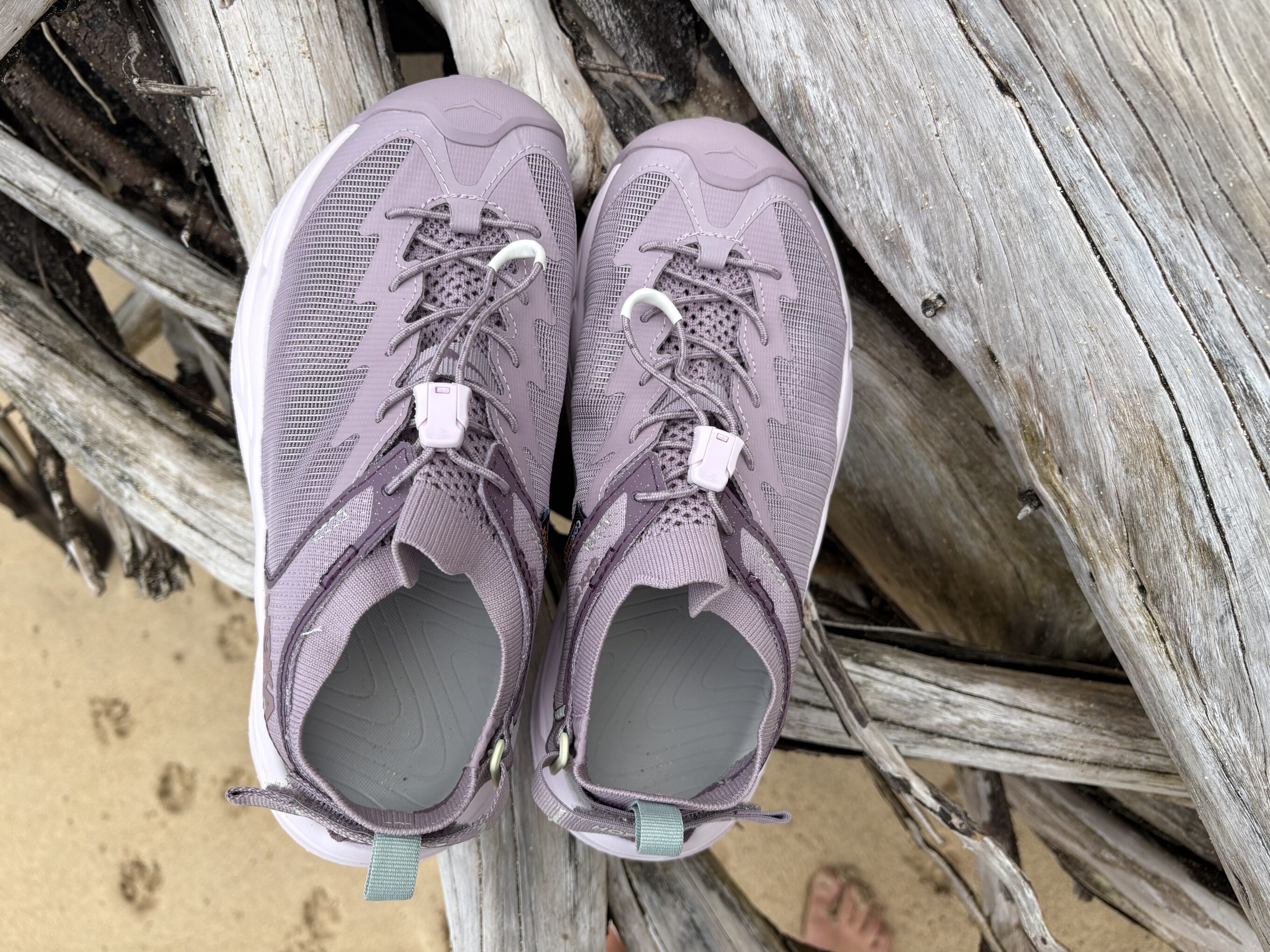 hoka sandals on a log