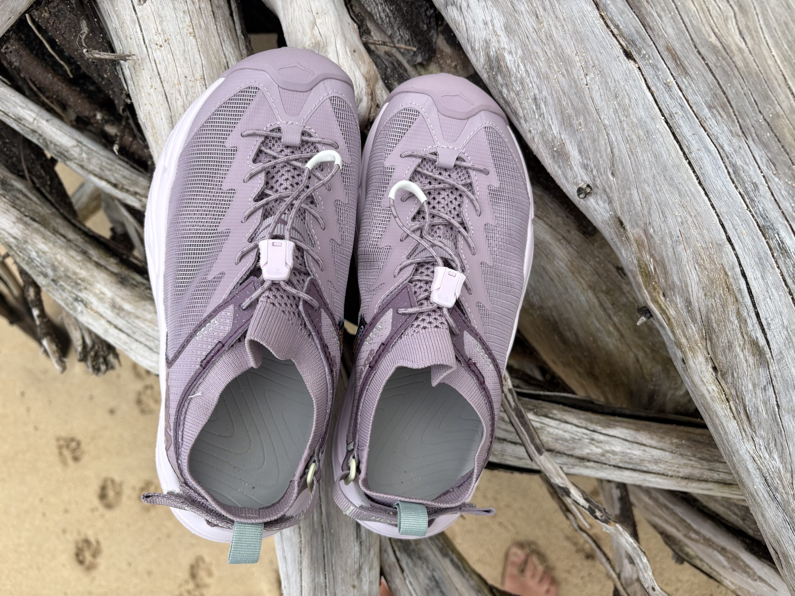 hoka sandals on a log