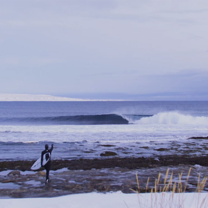 Dylan Graves pointing at a perfect wave in the Barents Sea