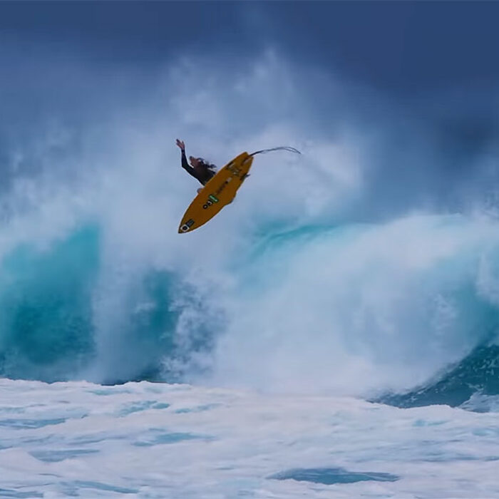 Matt Meola doing an air on a surfboard in Maui