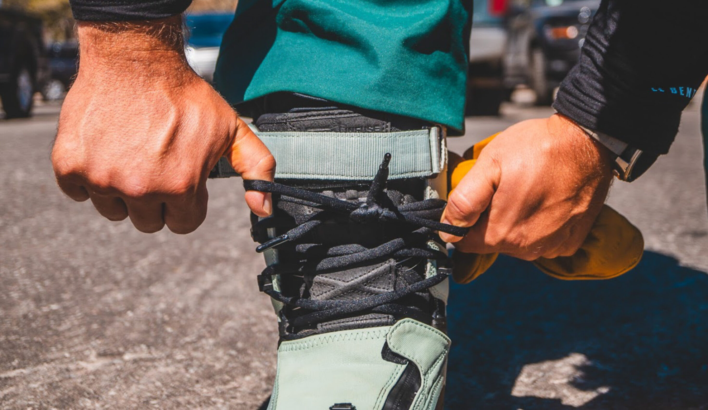 man lacing snowboard boots