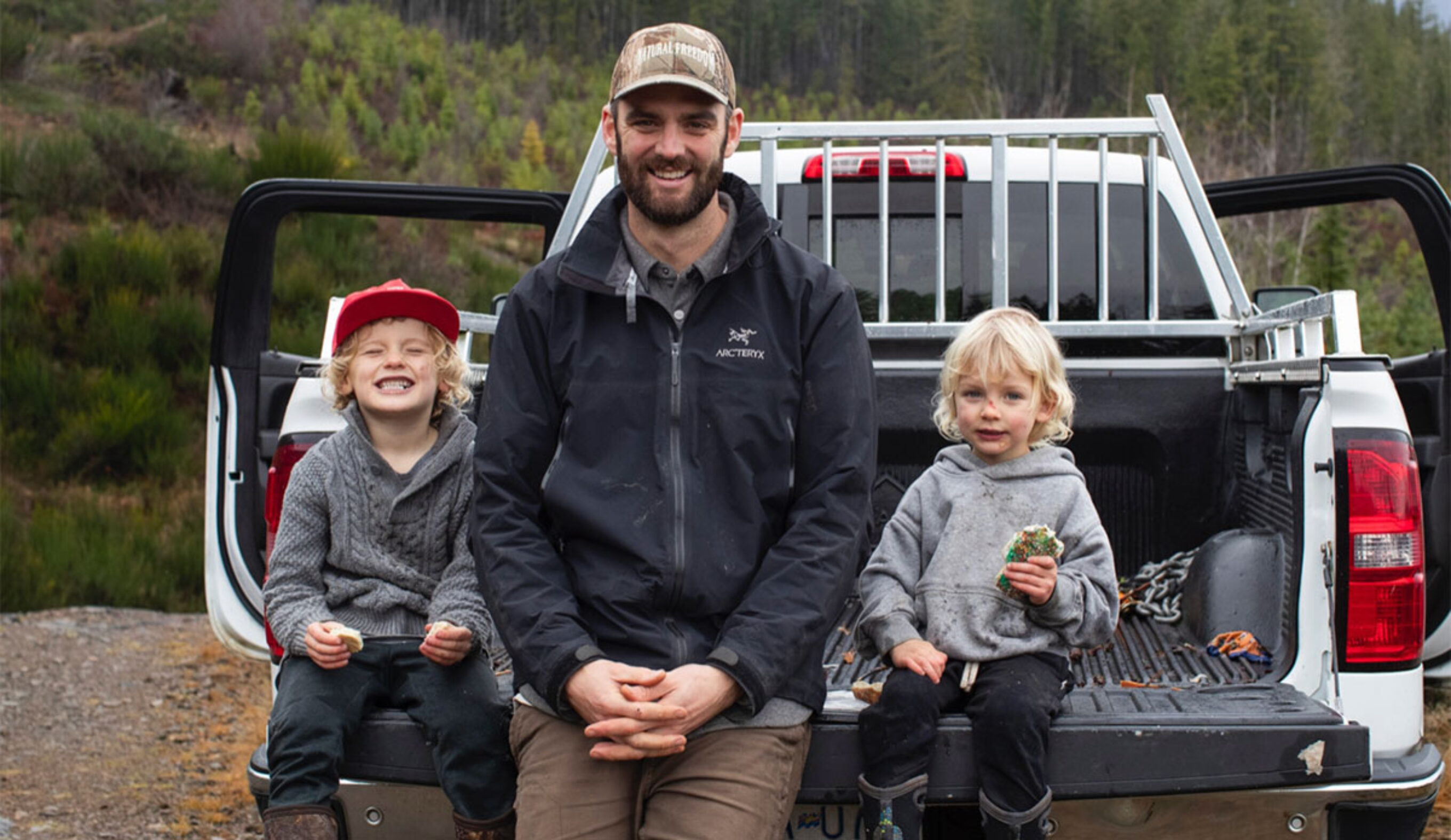 Kyler Voss sitting with two children