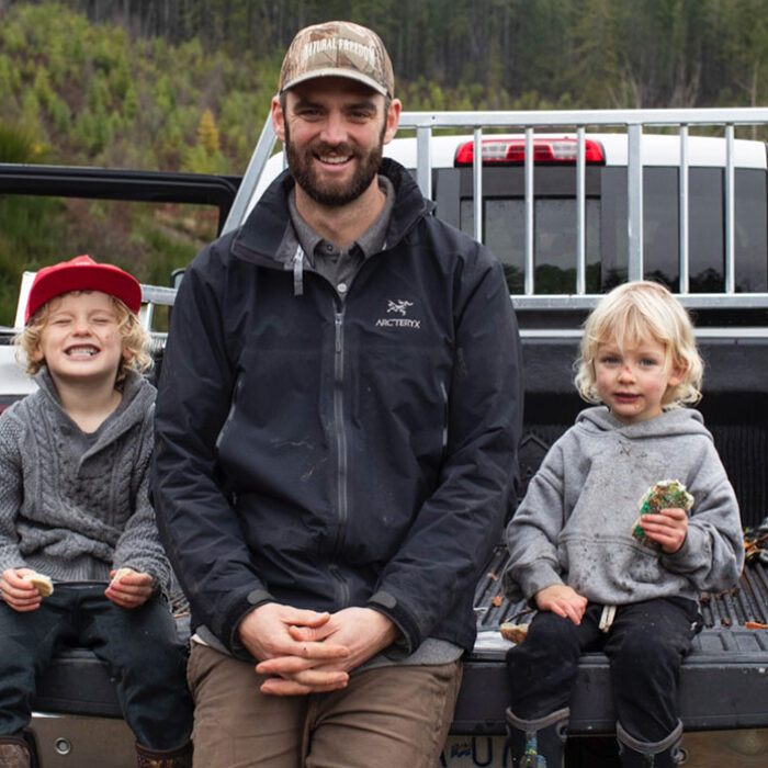 Kyler Voss sitting with two children